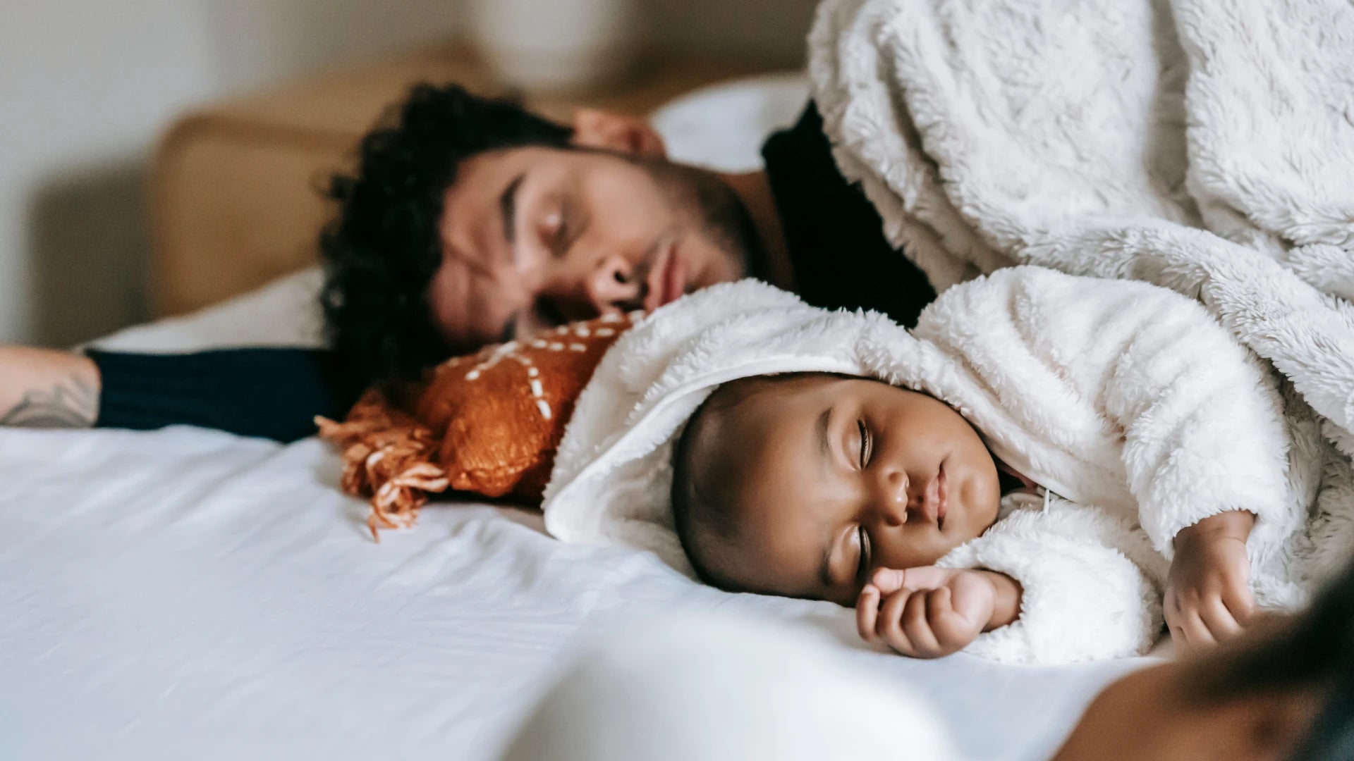 Un père fatigué dort avec son bébé 